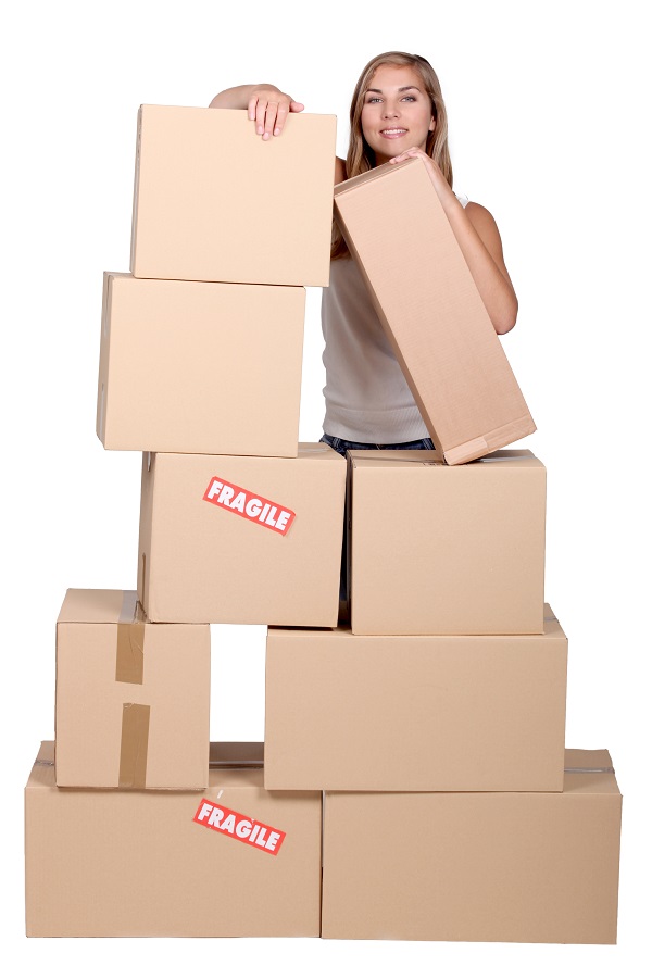 Young woman with a pile of cardboard boxes marked fragile